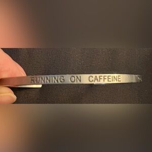 Brushed finish stainless steel cuff “Running On Caffeine” NWOT.